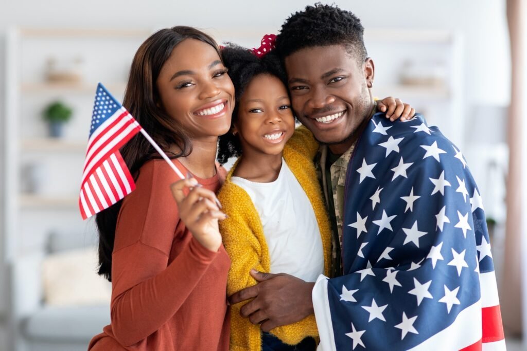 Family with service member wrapped in U.S. flag posing with wife and daughter
